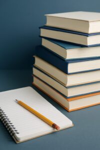 ノートと鉛筆、積み重ねられた本が並ぶ学習風景